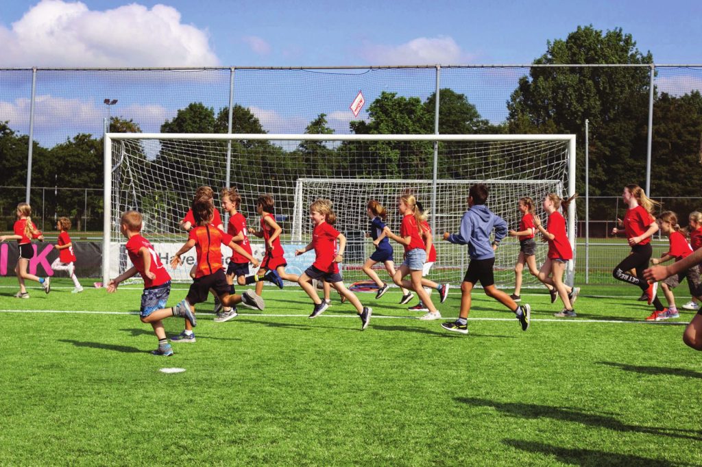 Kinderen van De Sportanen rennen samen over het sportveld